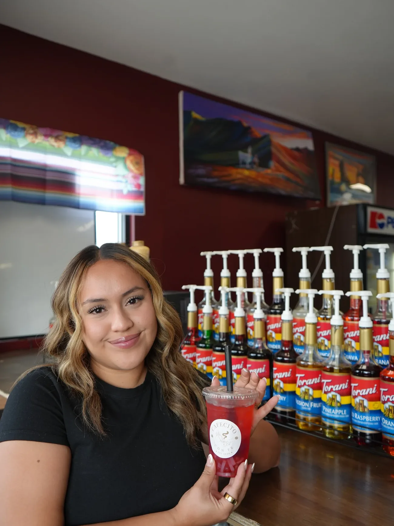 Karla, the owner of Cafecito Con Fe, behind the counter